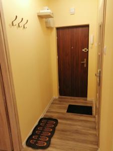 Habitación pequeña con puerta y alfombra en el suelo en Apartament Reymonta en Łowicz