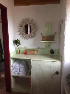 a bathroom with a mirror and a shelf with towels at Casa Rural Los Santillos in El Pinar del Hierro