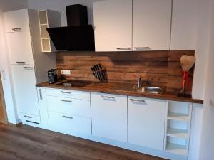 a kitchen with white cabinets and a sink at Apart Alexandra in Strass im Zillertal