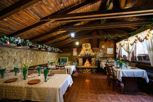 a restaurant with tables and chairs and a fireplace at Hotel Chichin in Bansko