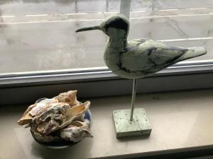 a statue of a bird next to a bowl of mushrooms at Duinenzicht 3 in De Haan