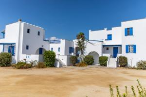 una fila di edifici bianchi con cortile di Surfer Paradise a Naxos Chora