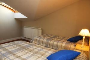 1 dormitorio con 2 camas y lámpara en Salamanca Centro Apartamentos, en Salamanca