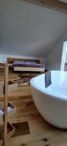 a white bath tub sitting on top of a wooden floor at Schöne Wohnung in Walenstadt in Walenstadt