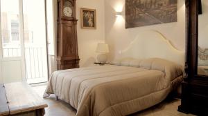 a bedroom with a bed with a clock on the wall at La Maison in Taranto