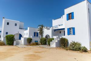 a row of white houses with blue windows at Surfer Paradise in Naxos Chora