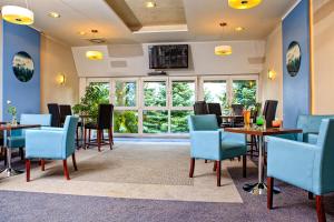 a restaurant with tables and chairs and a large window at Hotel Karolinka in Karpacz