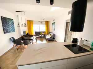 een keuken en een woonkamer met een tafel en stoelen bij Beautiful New Apartment with Sea View in Castillo de Sabinillas