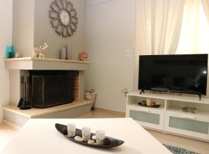 ein Wohnzimmer mit einem TV und einem Kamin in der Unterkunft Modern Riviera Azure Residence close to beach in Athen