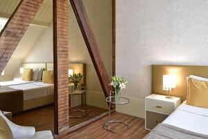 a room with a bed, mirror, and a dresser at My Story Hotel Ouro in Lisbon
