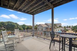 a patio with chairs and a table on a deck at Beachwalk Villas 23 in Folly Beach