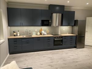 a kitchen with black cabinets and stainless steel appliances at Aurora Dream in Svensby