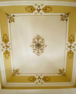 Cette chambre blanche est dotée d'un plafond blanc aux motifs dorés. dans l'établissement Beretti Home, à Catane