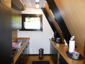 a small kitchen with a counter and a window at Ferienhaus Mauer Krombachtalsperre, exclusive Nebenkosten Strom in Driedorf