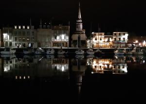 une ville de nuit avec des bateaux dans l'eau dans l'établissement Atelier 39bis, à Honfleur