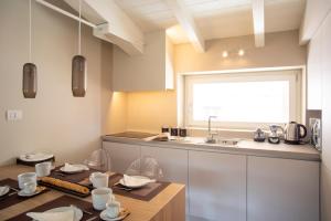 a kitchen with a table and a sink at Time to Be - Luxury Apartments Centro Storico in Peschiera del Garda +57 photos