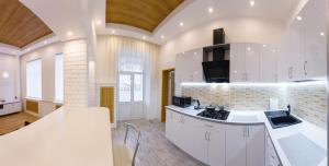 een keuken met witte kasten en een fornuis met oven bij Apartments on Independence Square in Kiev