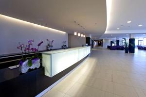 a lobby with a reception counter and flowers in a building at Hotel Molindrio Plava Laguna in Poreč