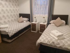 a bedroom with two beds and two night stands at The Vale Hotel in Hull