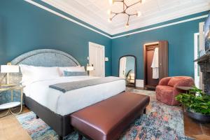 a bedroom with blue walls and a bed and a chair at The Albert Mosman in Sydney