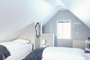 2 łóżka w pokoju na poddaszu w obiekcie Iðavellir Guesthouse w mieście Skagaströnd