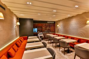 a restaurant with tables and chairs in a room at Apartmani Luka - Vila Brzulovic in Rafailovici