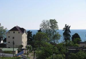 a large white house with the ocean in the background at Hotel Breez in Lazarevskoye