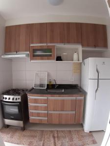 a small kitchen with a stove and a refrigerator at Apartamento Martinica 2 in Caraguatatuba
