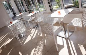 a row of tables and chairs in a room with windows at Hotel Rubens in Rimini