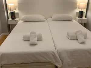 twee bedden met handdoeken in een slaapkamer bij São Jorge Castle view Apartment in Lissabon