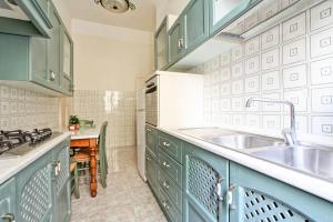 una cucina con armadi verdi e lavandino di Roman Apartment a Roma