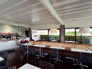 un comedor con mesas, sillas y ventanas en Mt Albert Motor Lodge, en Auckland