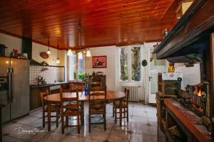 uma cozinha com uma mesa, cadeiras e um forno em La VILLA ILIXON em Luchon