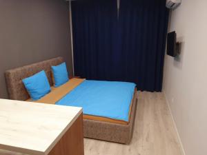 Schlafzimmer mit einem Bett mit blauer Bettwäsche und einem Stuhl in der Unterkunft Apartservice in Uzhgorod s39 in Uschhorod