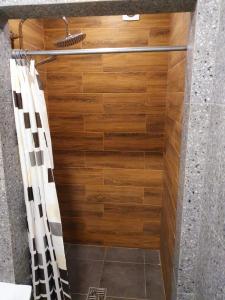eine Dusche mit einer Holzwand und einem Duschvorhang in der Unterkunft Apartservice in Uzhgorod s39 in Uschhorod