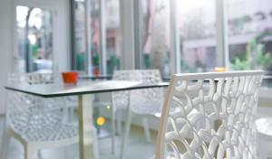 a table and chairs in a room with a window at Hotel Rubens in Rimini