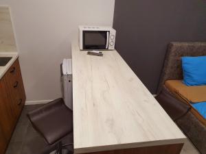 einen Holztisch mit einer Mikrowelle und einem TV darauf in der Unterkunft Apartservice in Uzhgorod s39 in Uschhorod