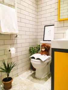 a teddy bear sitting in a toilet in a bathroom at Banana Apartments in Batumi