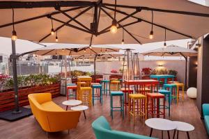 un ristorante con sedie e tavoli colorati e ombrelloni di Libre Hotel, BW Signature Collection by Best Western a Lima