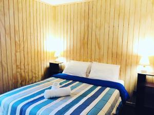a bedroom with a bed with two towels on it at Hostal Origen Patagonia in Punta Arenas