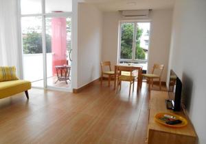 a living room with a table and chairs and a television at Redhouse Boutique in Sihanoukville