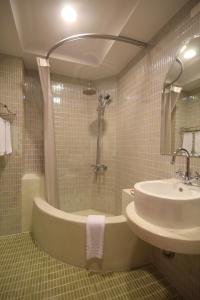 a bathroom with a tub and a sink and a shower at Moroccan Holiday Suite in Hualien City