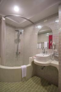 y baño con lavabo, bañera y espejo. en Moroccan Holiday Suite, en Hualien City