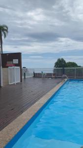 a large swimming pool on a wooden deck at Condomínio residencial mar azul in Imbituba