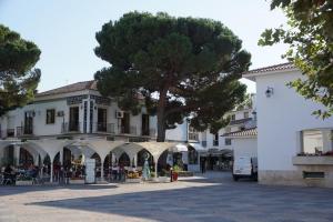 un edificio con un albero in mezzo a una strada di Quartos confortáveis em casa próximo ao Mosteiro a Batalha