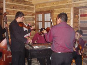 un gruppo di persone che suonano strumenti in una stanza di penzion Drevenica a Šumiac