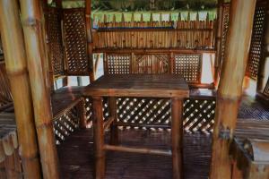 Nature Care Resort and Farm في Pulilan: طاولة وكراسي خشبية في الغرفة