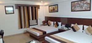 een hotelkamer met 2 bedden en een raam bij Hotel Su Shree Continental 5 Minutes Walk From New Delhi Railway Station in New Delhi