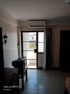 een kamer met een deur met een raam en een piano bij V.I.P. House in Chiang Mai