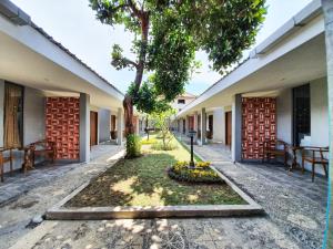 einen Innenhof mit einem Baum in der Mitte eines Gebäudes in der Unterkunft Sanur Agung Suite in Sanur